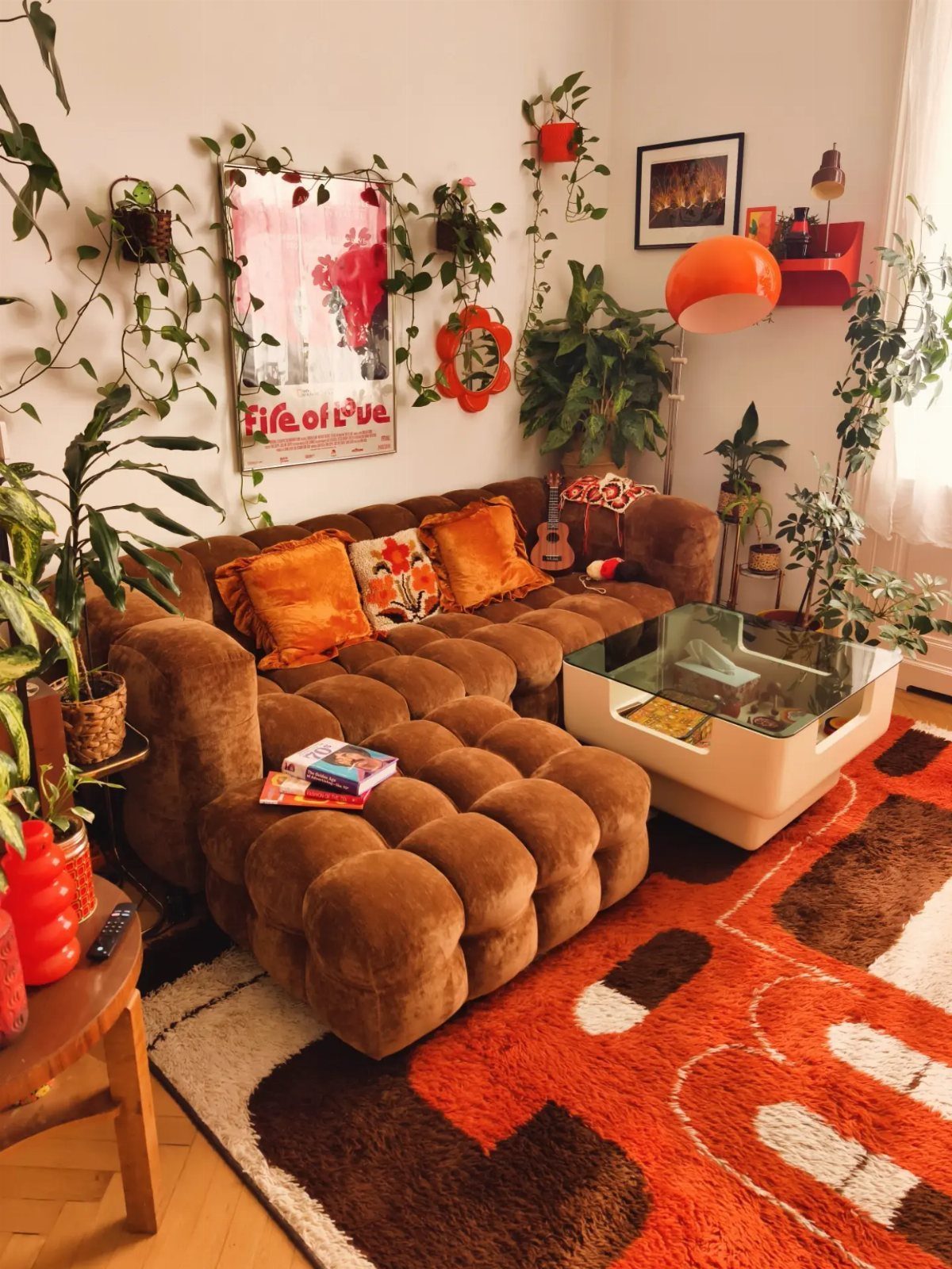 Brown tufted velvet sofa and orange shag rug in a 70s living room