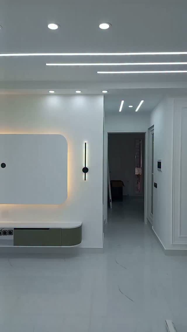 Wall-mounted white panel with warm LED backlighting above a floating modern console.
