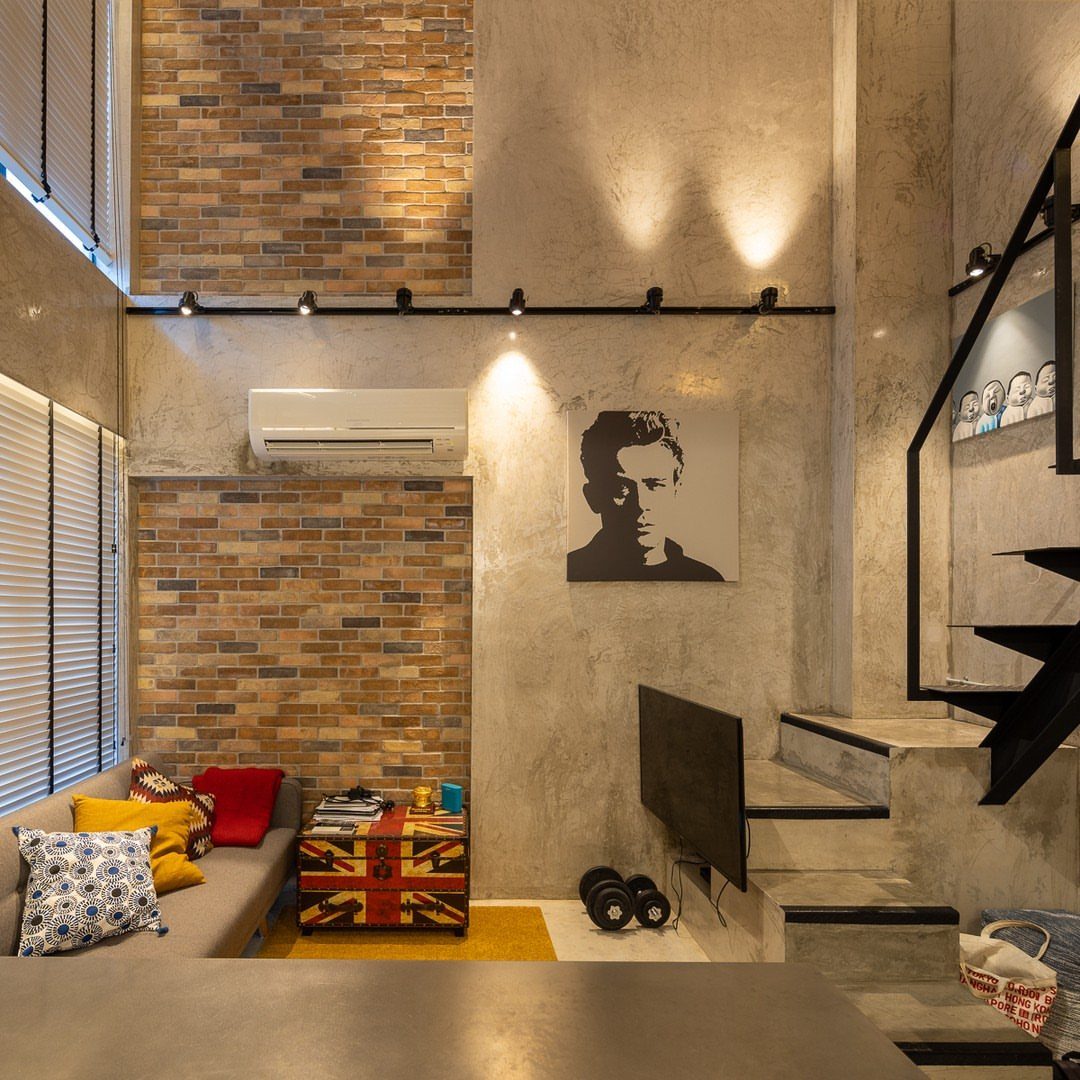 Industrial living room with concrete walls, brick accents, and a Union Jack table.