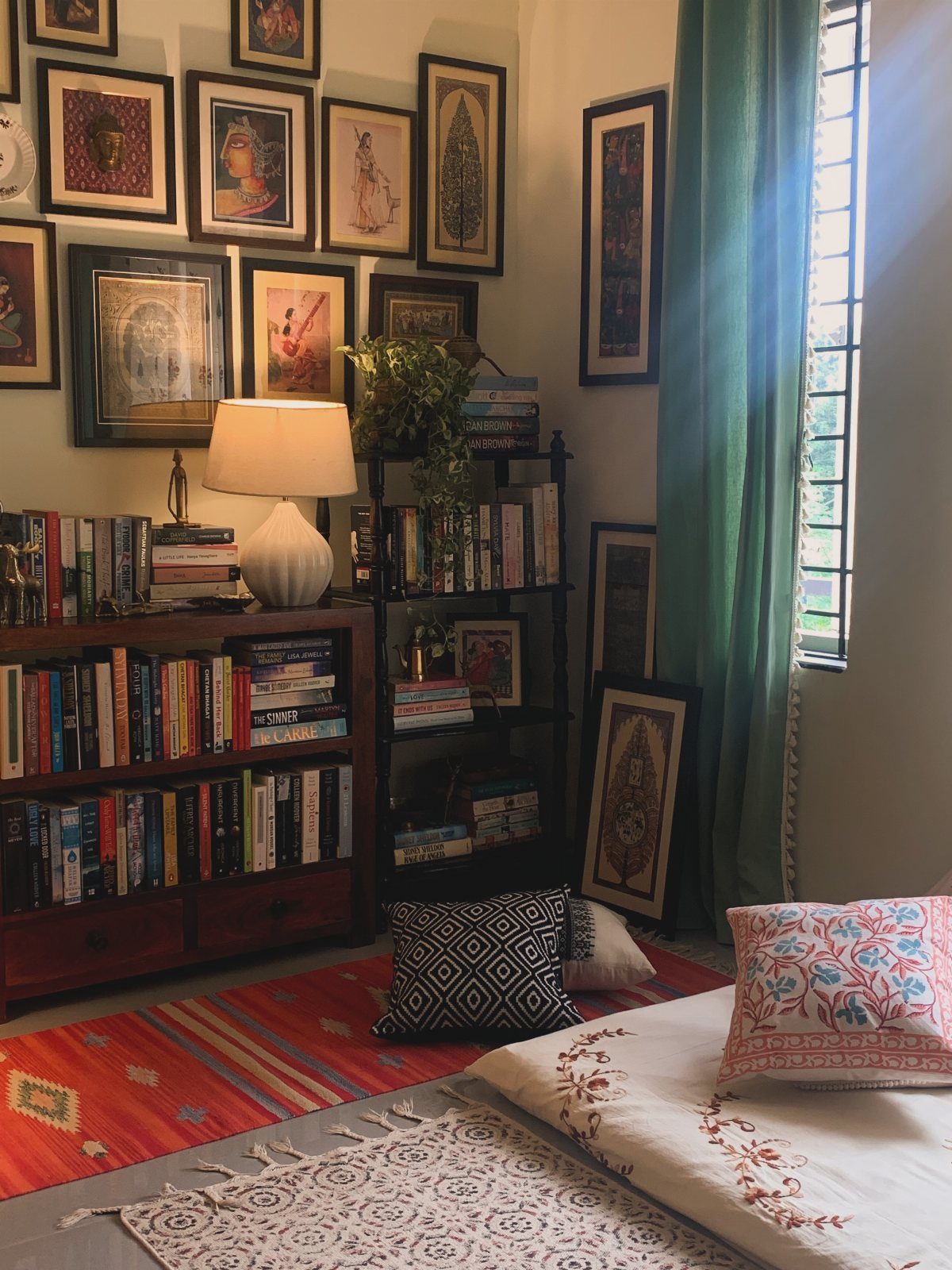Open shelving bookshelf filled with books next to a wall of framed art.