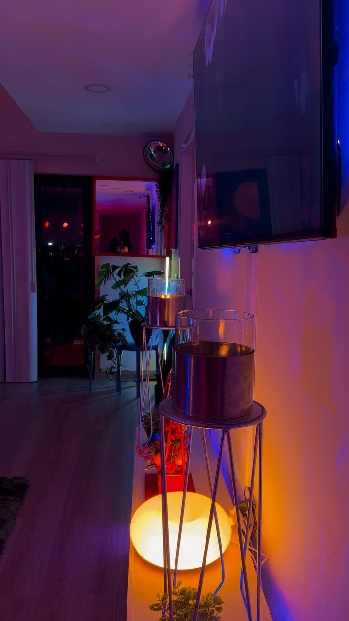 Wall mounted television in a room with blue and orange ambient lighting.