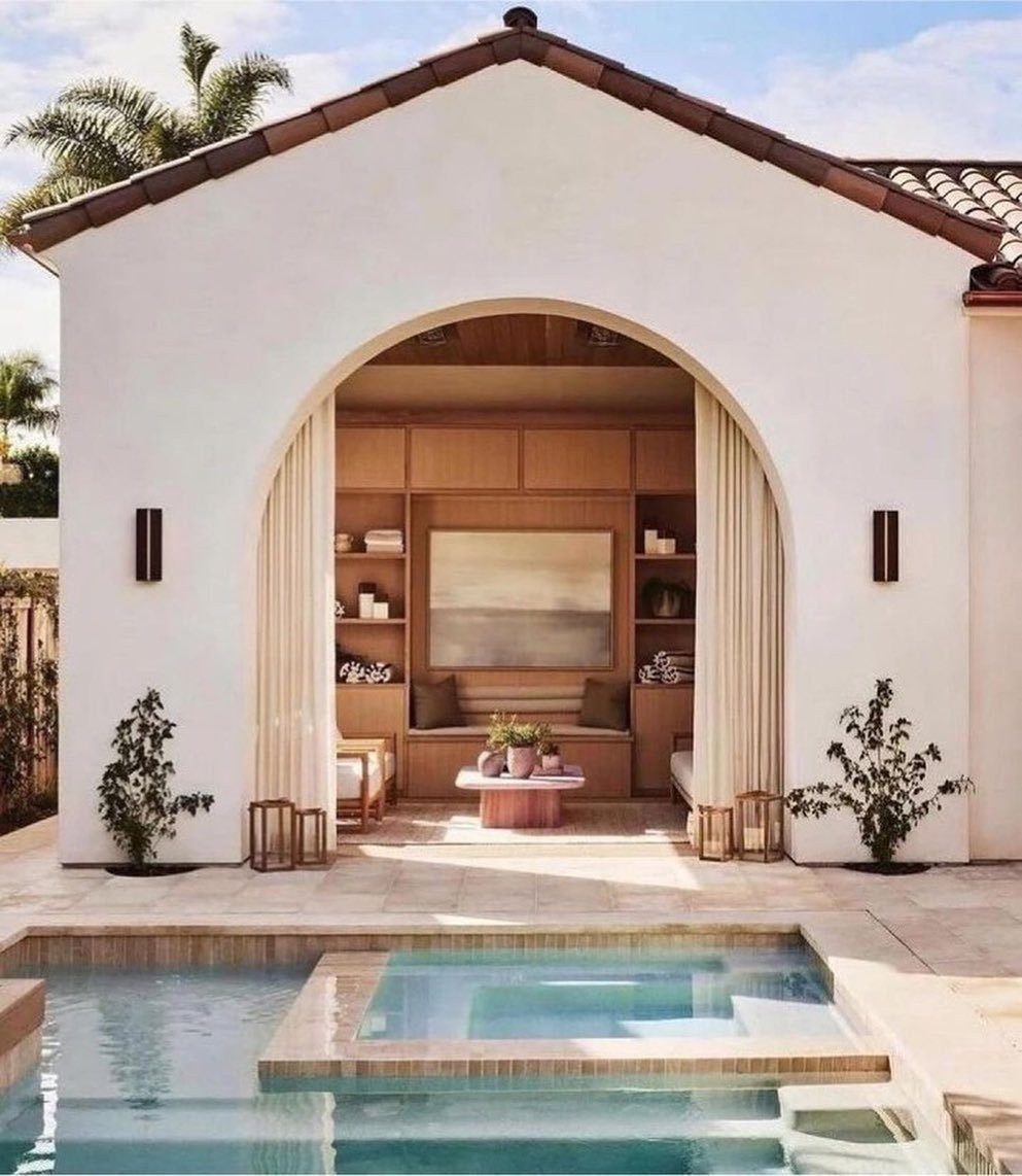 Large arched doorway opening from a poolside patio into a coastal living space