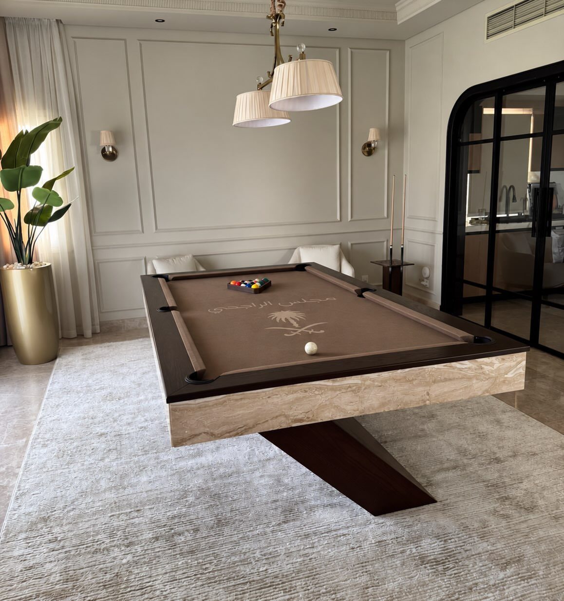 Modern brown pool table with stone base in a white paneled room