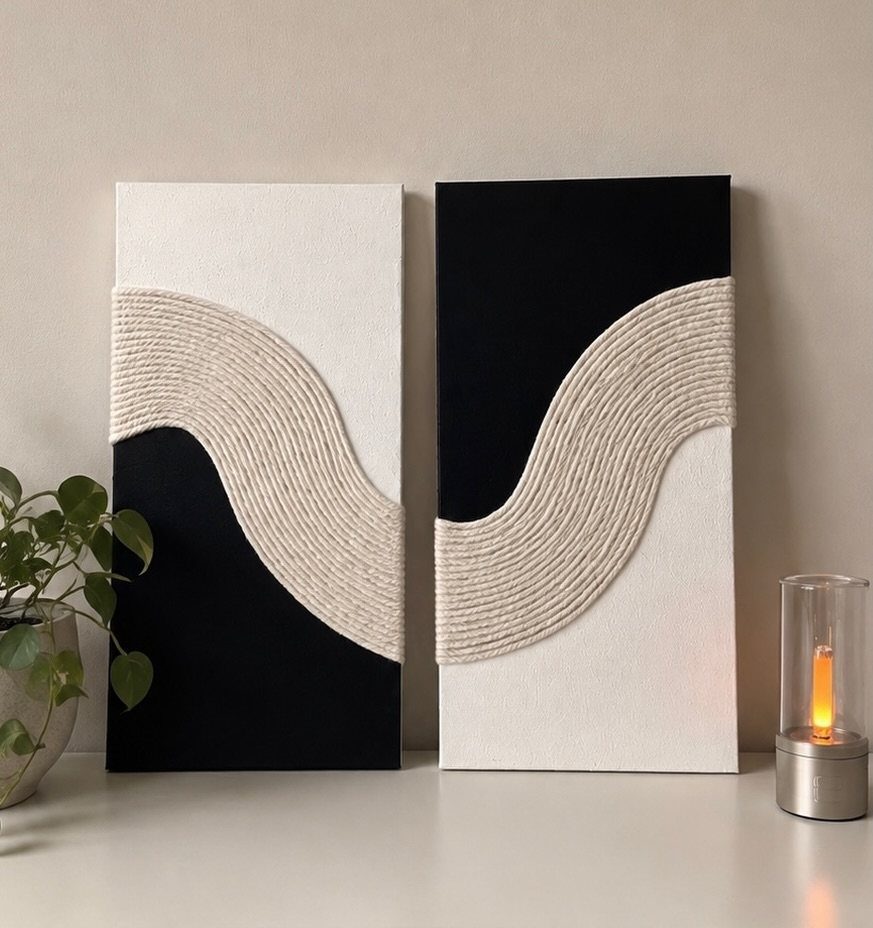 Two black and white canvas art panels with textured beige wavy rope details.