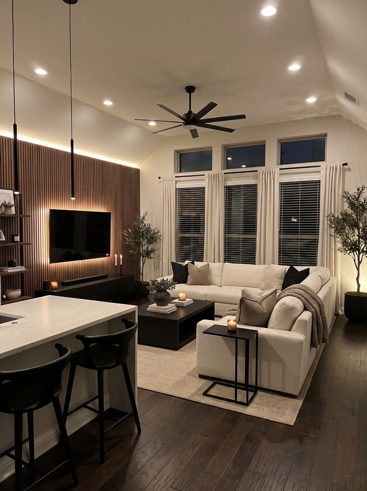 Modern living room with dark wood floors, white walls, and white sectional sofa.