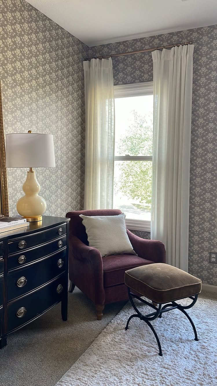 White sheer curtains and blinds on a window in a cozy reading nook.