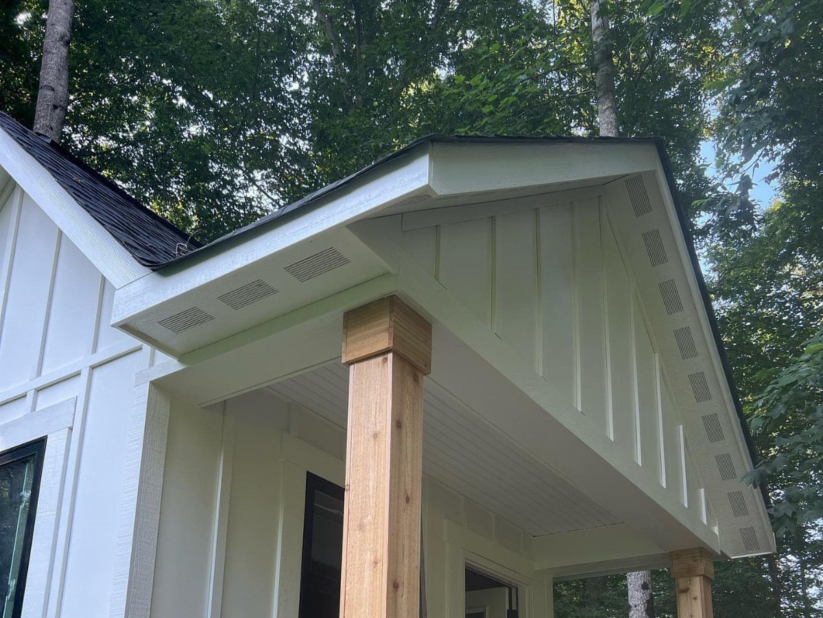 White board and batten siding on a house porch with a wooden pillar.
