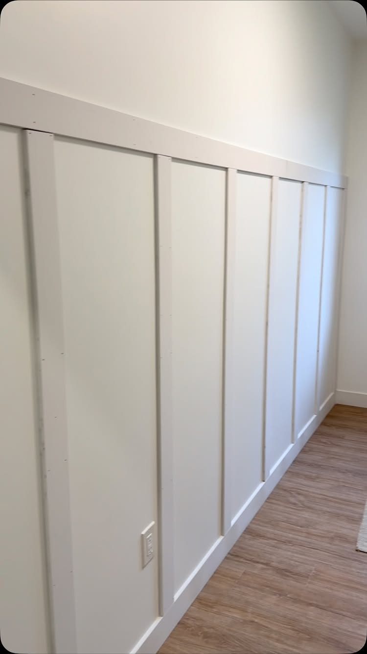 White board and batten wall with vertical strips and a horizontal top rail.