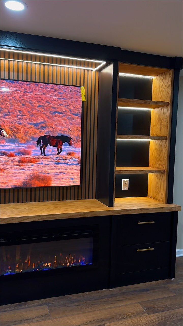 Modern entertainment center with integrated LED lighting on open wooden shelves and fireplace.