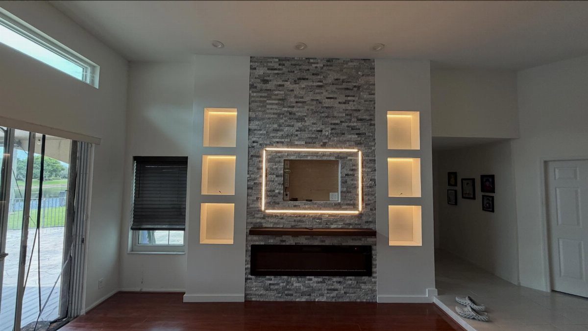 Modern stone accent wall with backlit inset and illuminated recessed shelving units.