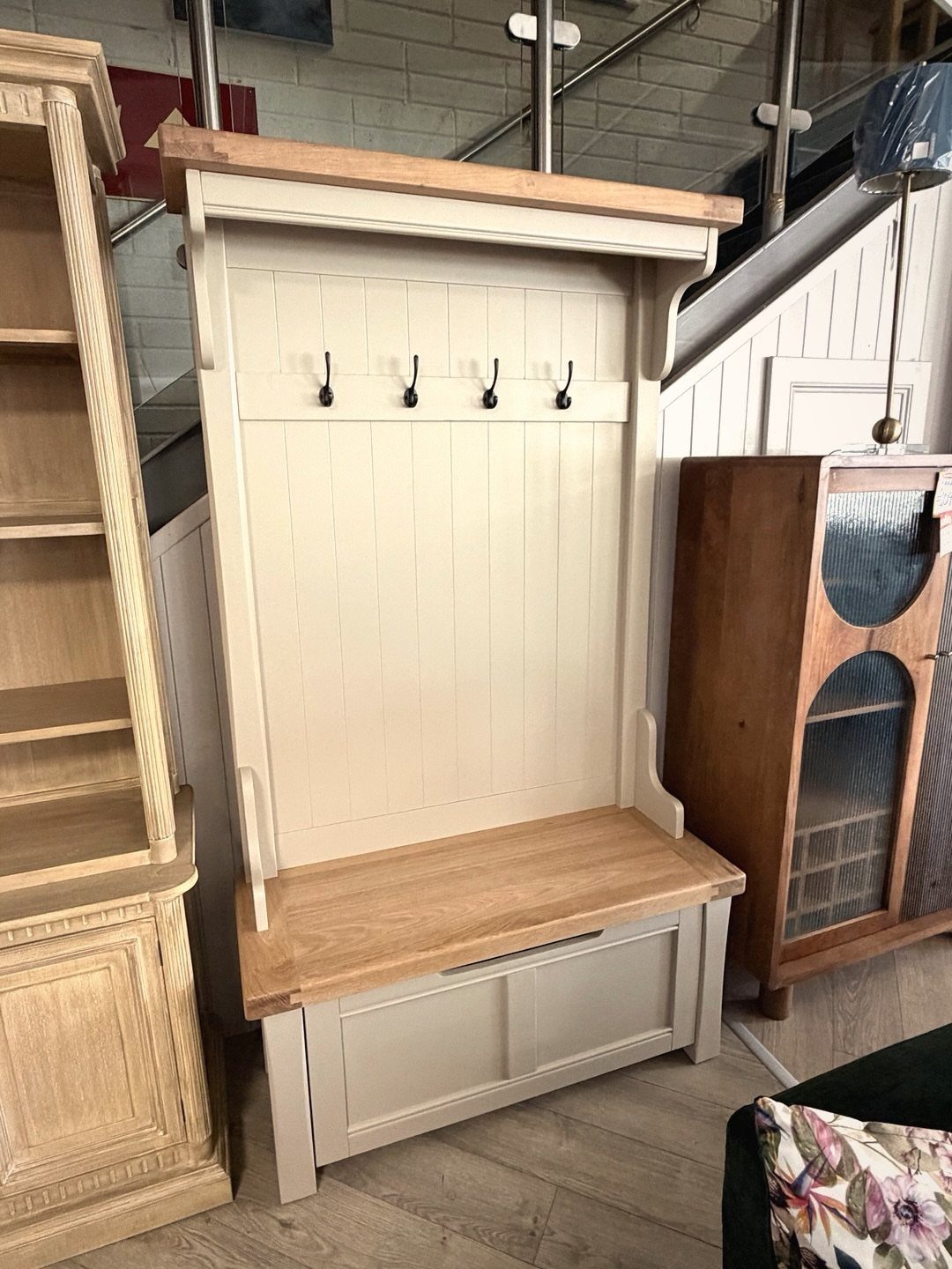Cream wooden hall tree with natural wood bench and four black coat hooks.