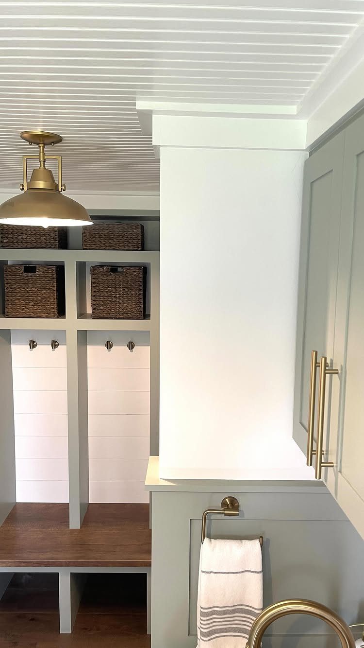 White beadboard panels installed on a ceiling above a grey mudroom with gold fixtures.