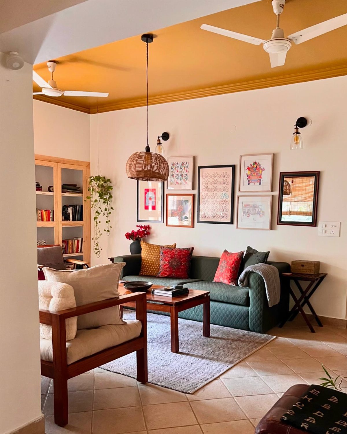 Yellow painted ceiling in a living room with a green sofa and wooden furniture