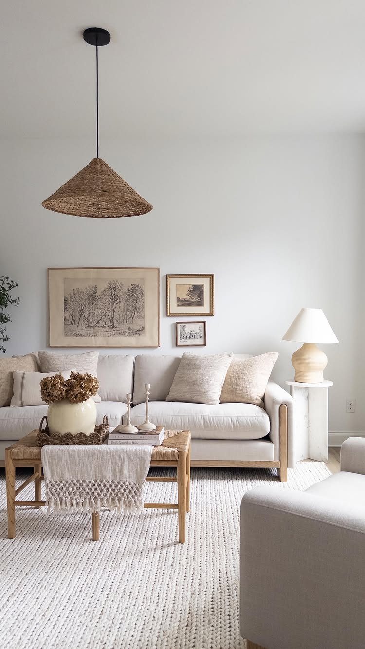 Neutral living room with a white sofa, wooden coffee table, and woven pendant light.