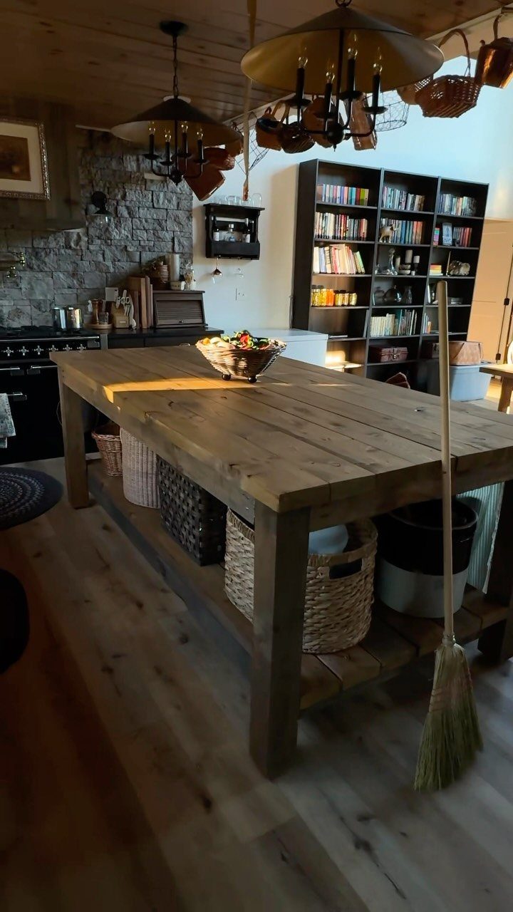 Rustic wooden kitchen island with baskets on a shelf in a country home.