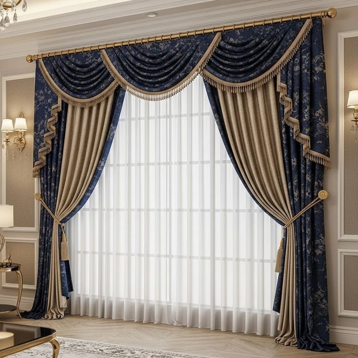 Blue and gold ornate curtains with a fringed valance over white sheer curtains.
