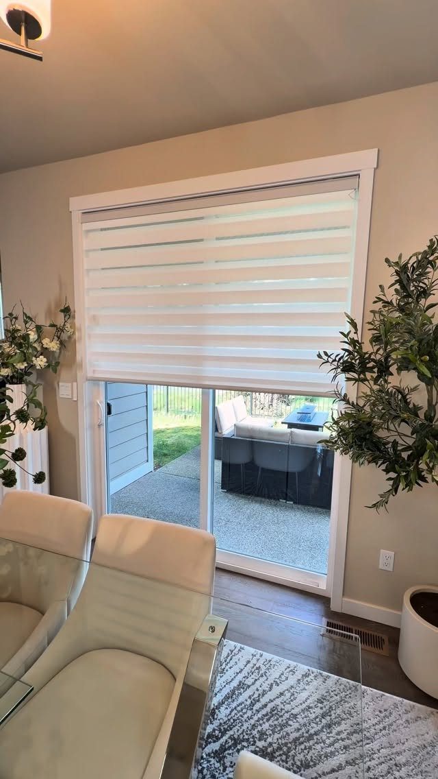 White striped zebra blinds partially covering a sliding glass door to a patio
