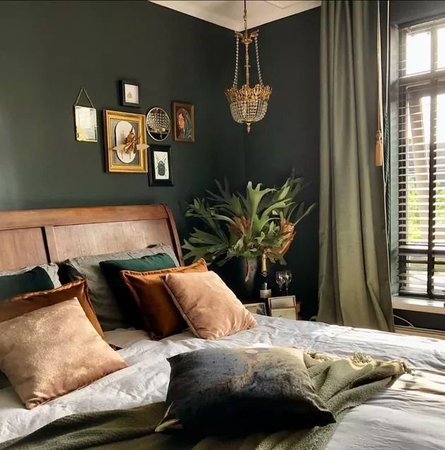 Olive green curtains and walls in a bedroom with a wooden bed.
