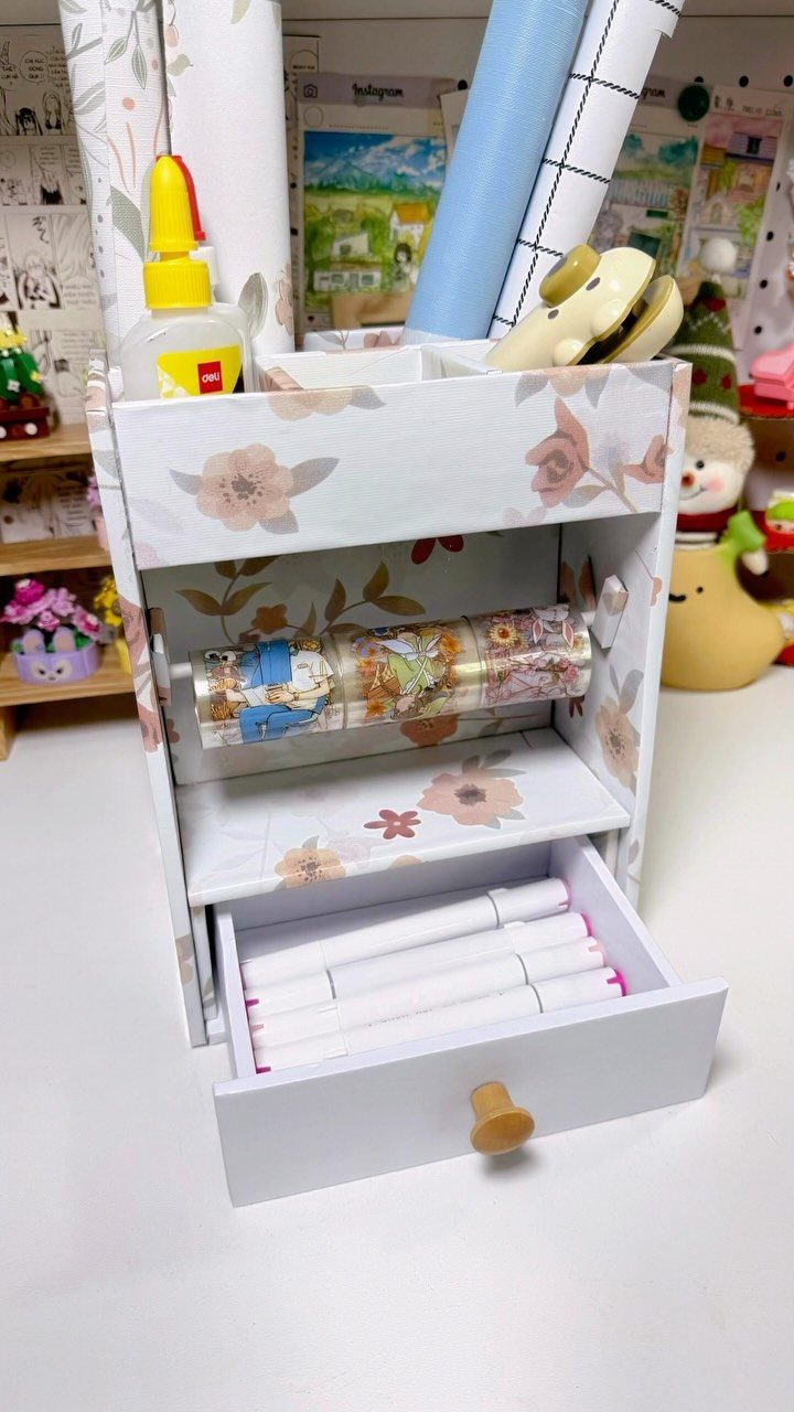 Floral desk organizer holding craft supplies and markers on a white surface