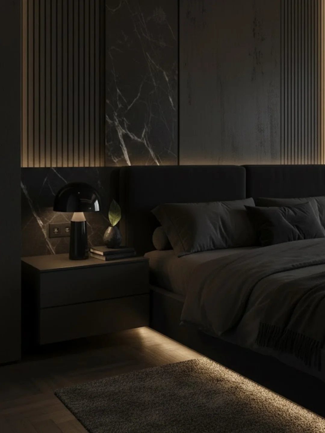 Dark bedroom with black furniture, marble wall panels, and warm accent lighting.