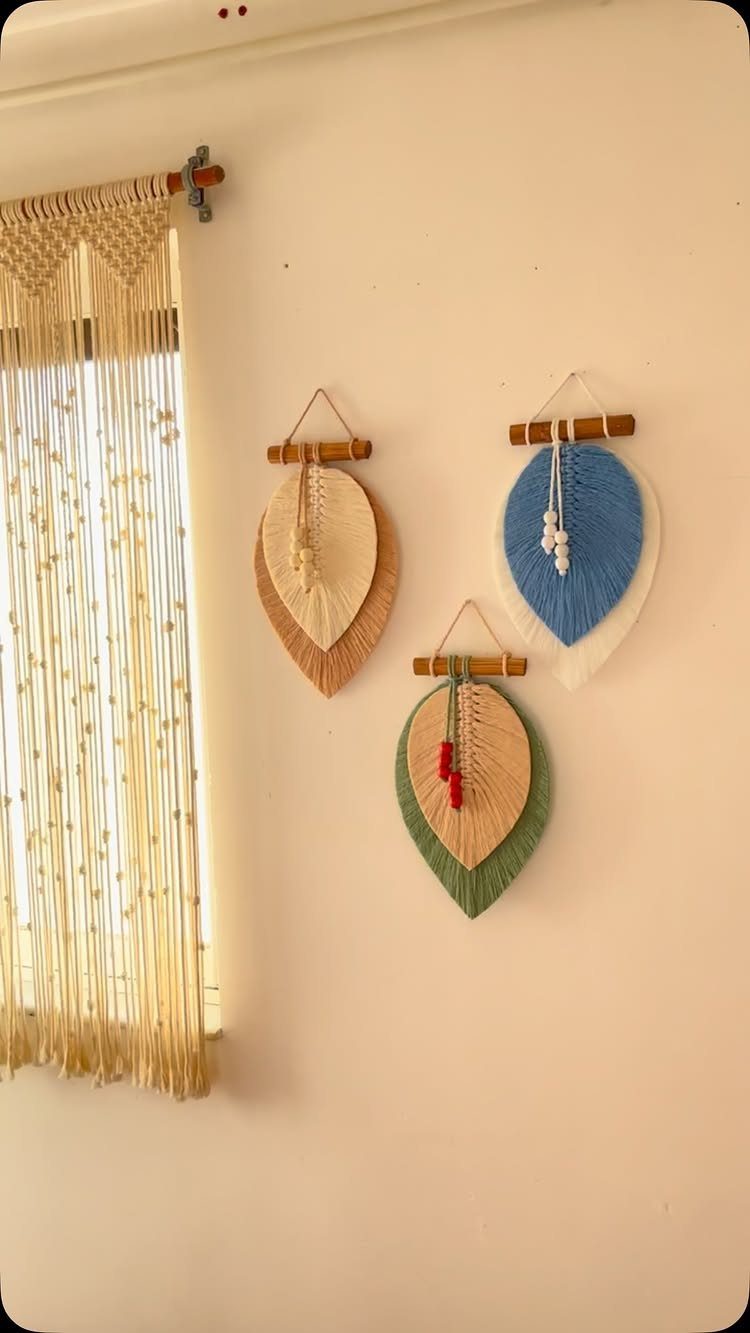 Macrame wall hangings including a large fringed piece and three colorful leaf-shaped designs.