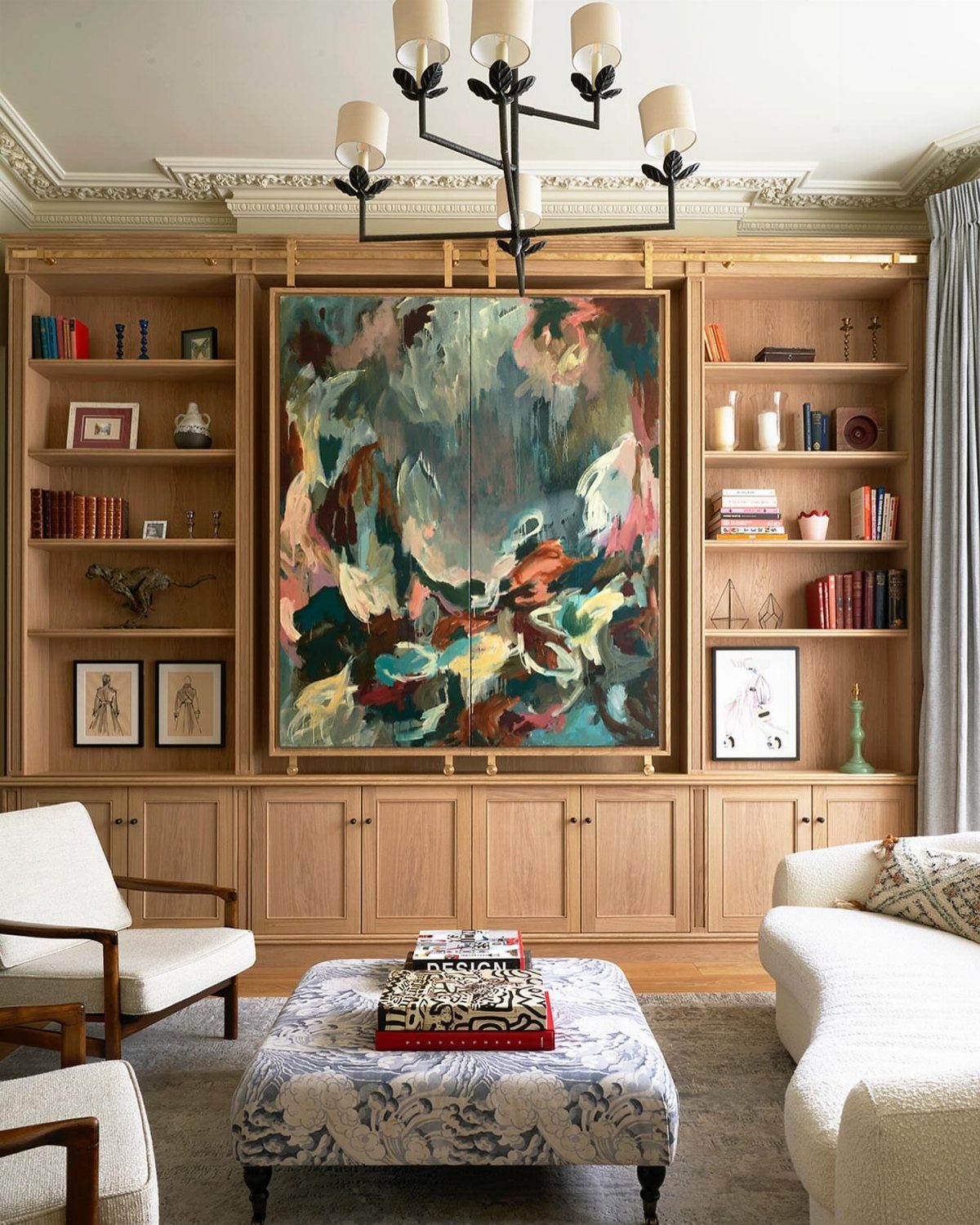 Drawing room with light wood bookshelves, abstract art, and a white sofa.