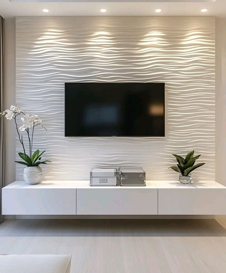 White floating TV console under a television on a wavy textured wall.