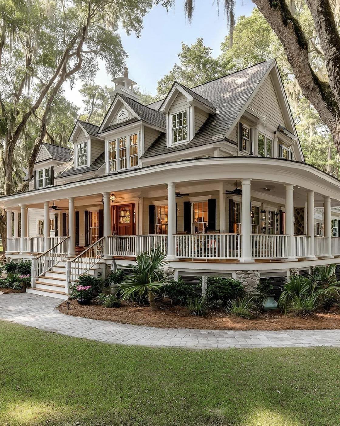 Large house with a curved wraparound porch, white columns, and a stone walkway.