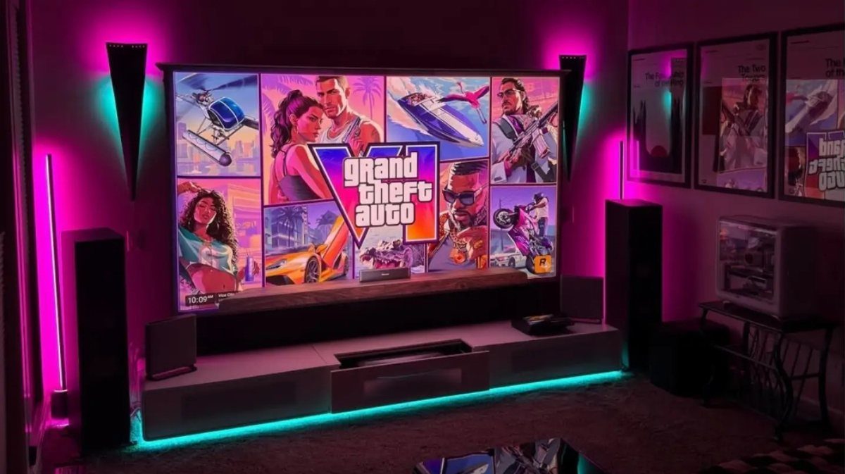 Gaming setup with a large screen and vibrant pink and cyan LED lighting.