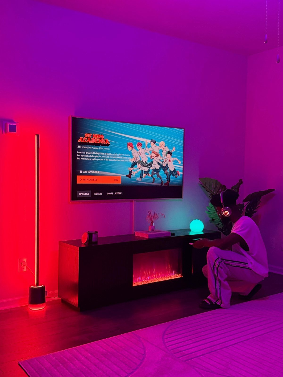 Tall red LED floor lamp standing next to a gaming TV setup.