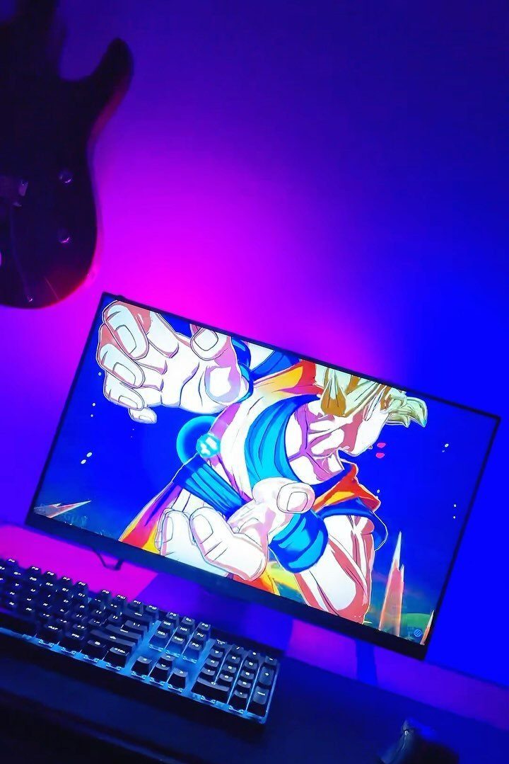 Computer monitor with anime art and purple and blue LED backlight on wall
