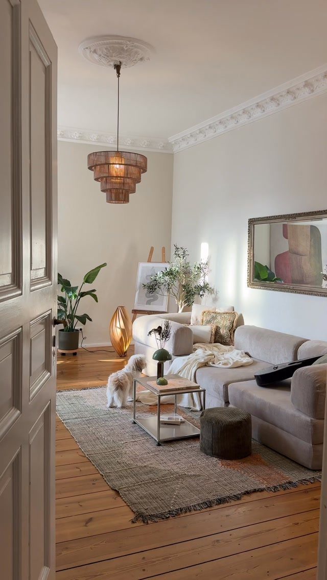 Beige L-shaped sofa and grey rug in a bright, minimalist living room.