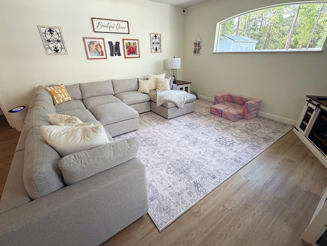 Large patterned area rug under a grey L-shaped sectional sofa in a living room