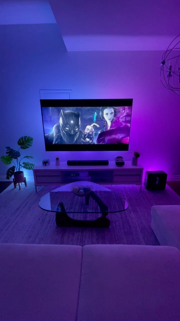 Television with purple and blue bias lighting glowing against a white wall