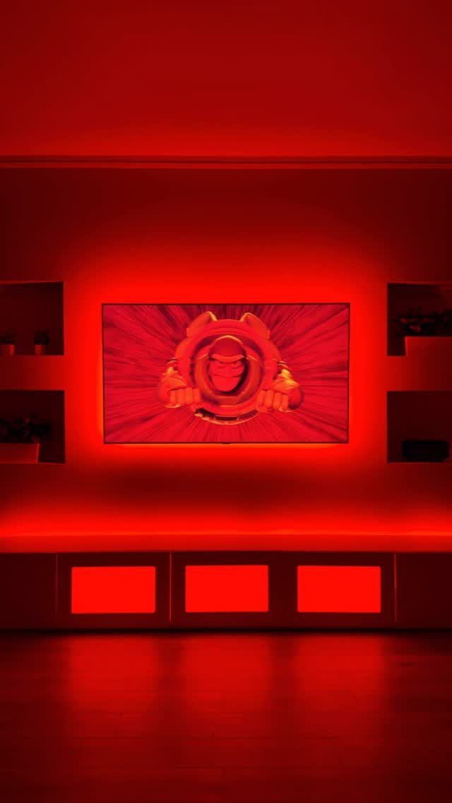 Home theater room with red ambient lighting and glowing rectangular wall panels.