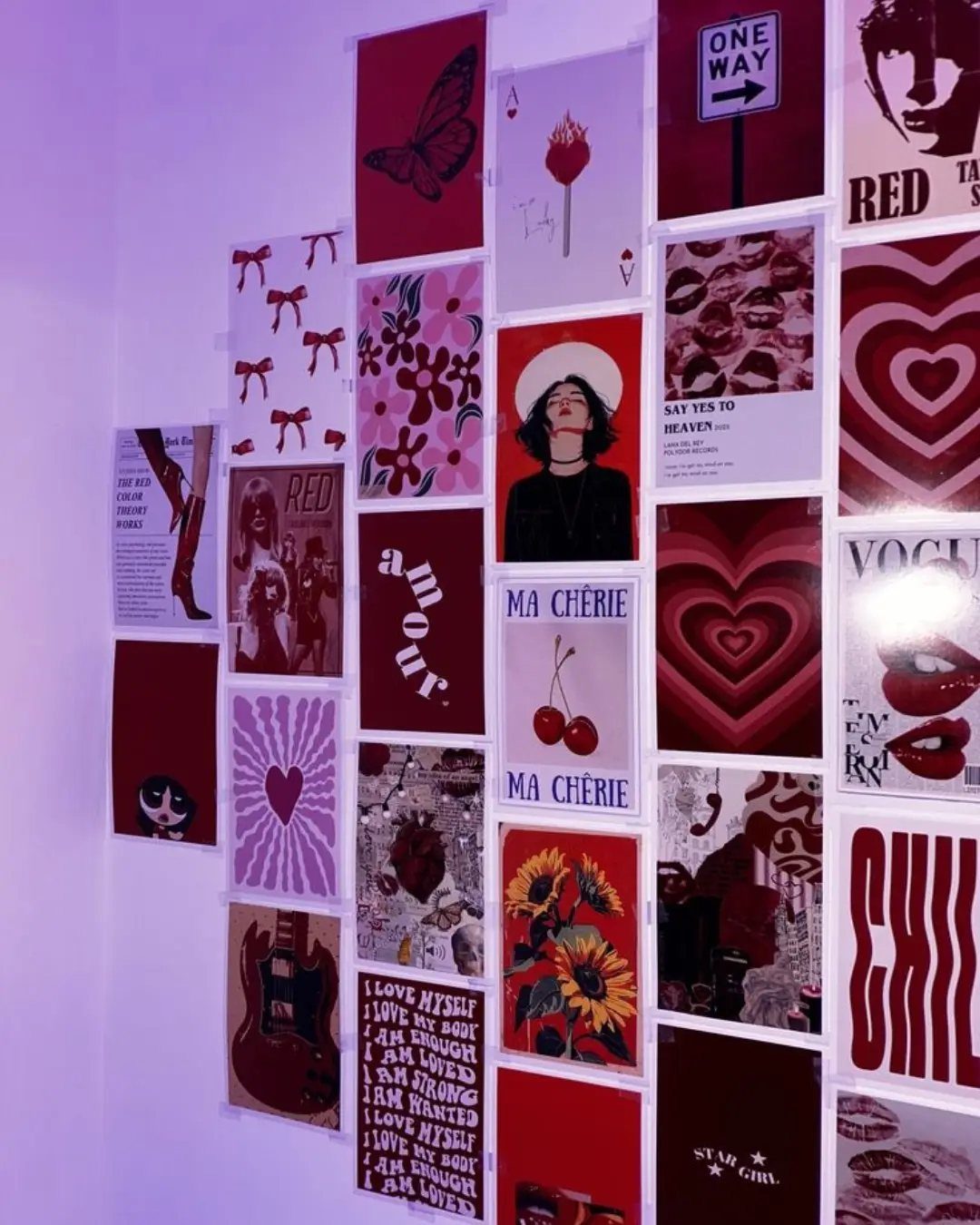 Red and pink themed art prints arranged in a grid on a wall.