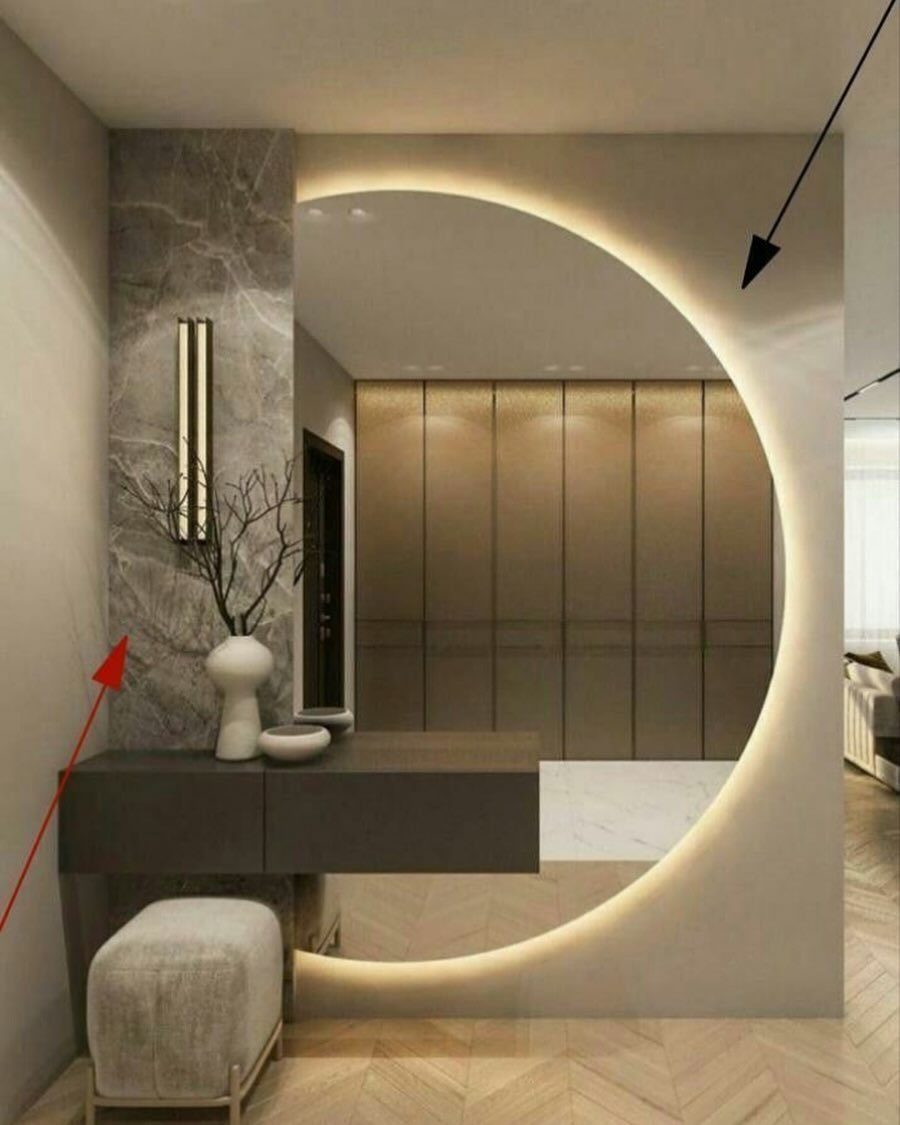 Circular backlit mirror above a dark grey vanity in a modern room