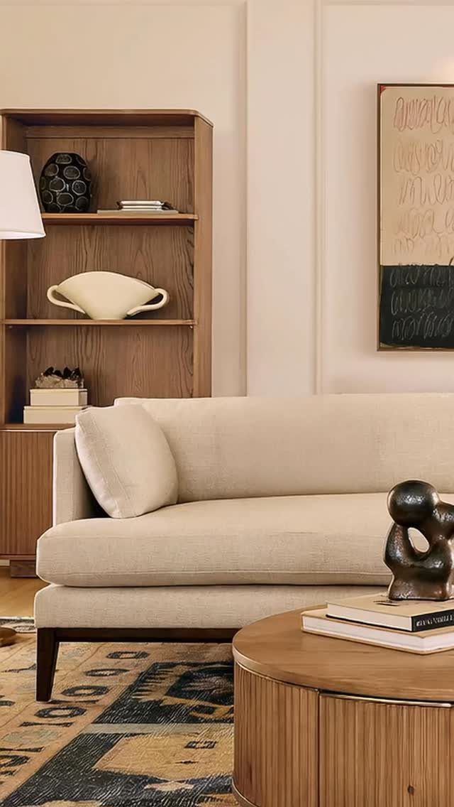 Cream sofa with dark tapered legs in a mid-century modern living room setting.