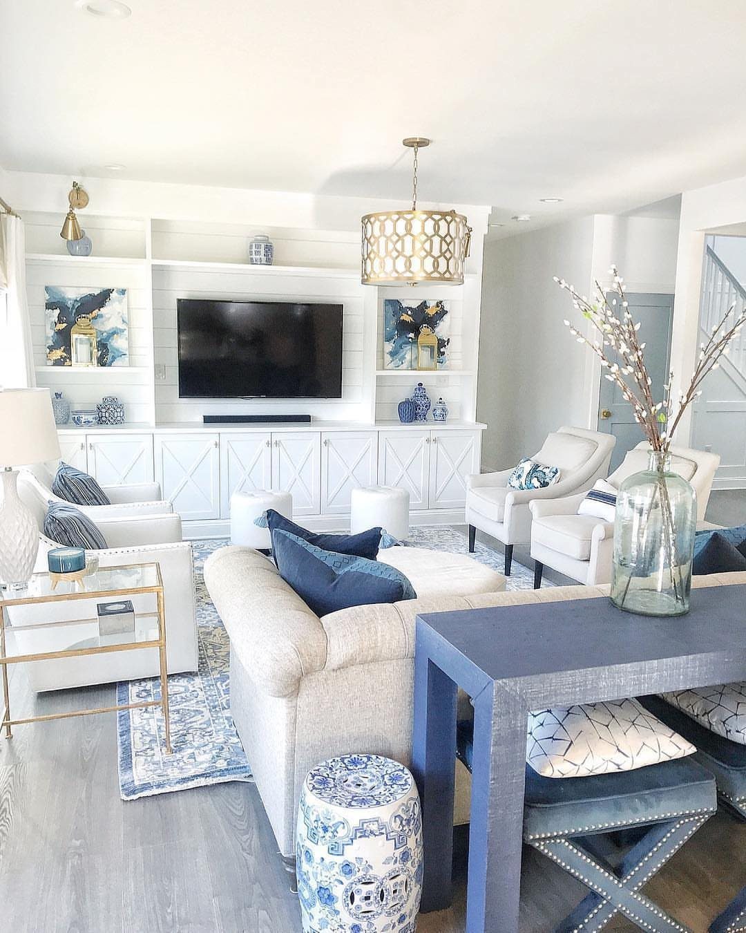 Bright living room with white furniture and various light blue decor accents.
