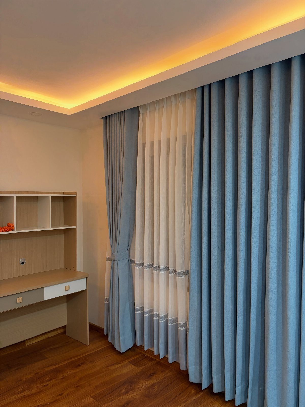 Light blue curtains and white sheers framing a window in a modern room.