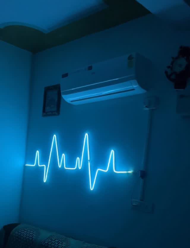 Blue neon heartbeat light glowing on a wall below an air conditioner