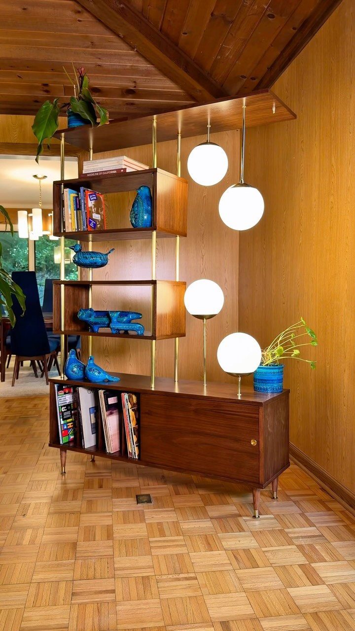Mid-century modern wooden wall unit with globe lights and blue decorative accents.
