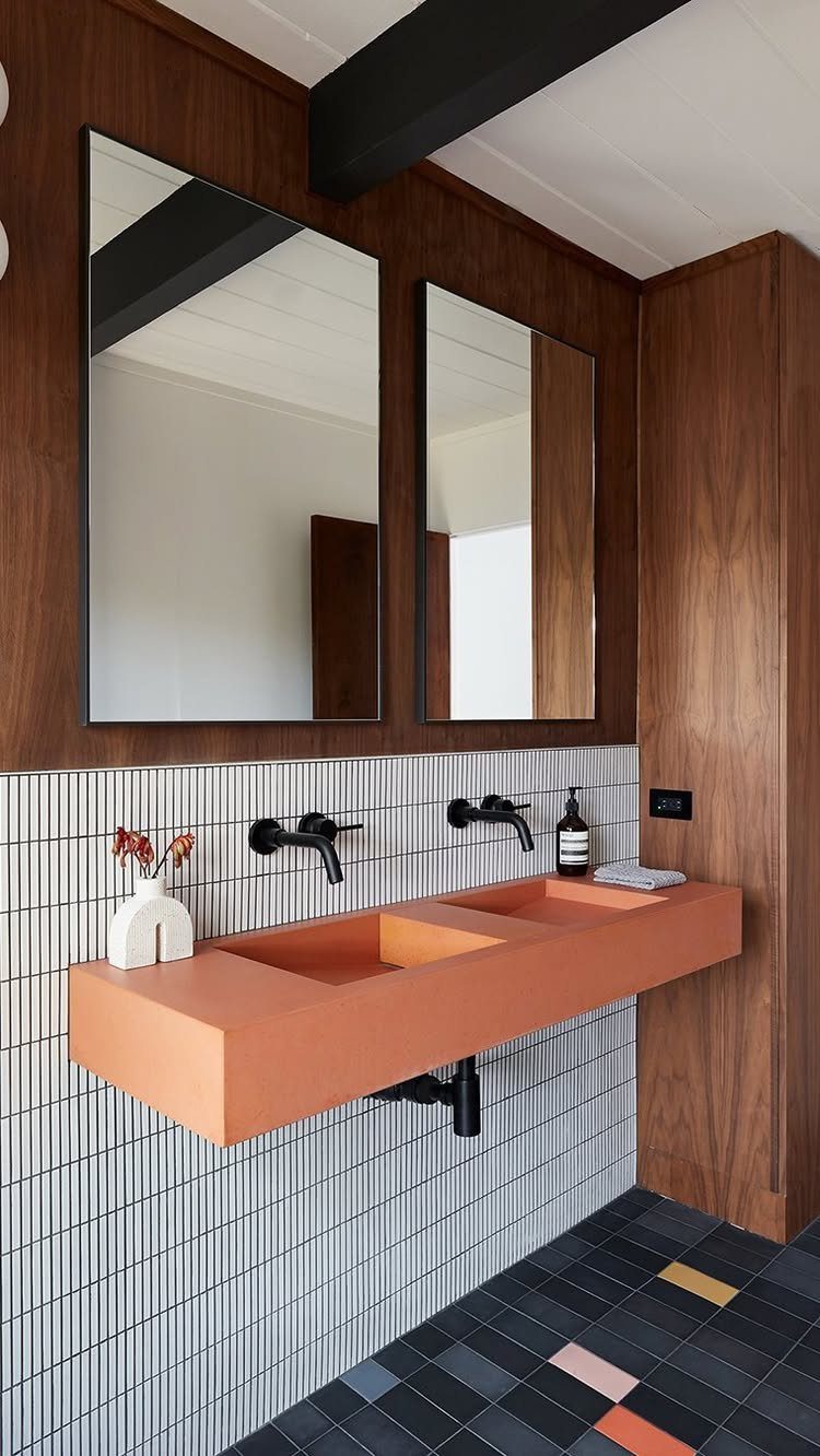 Terracotta double sink in a bathroom with wood paneling and white tiled walls.