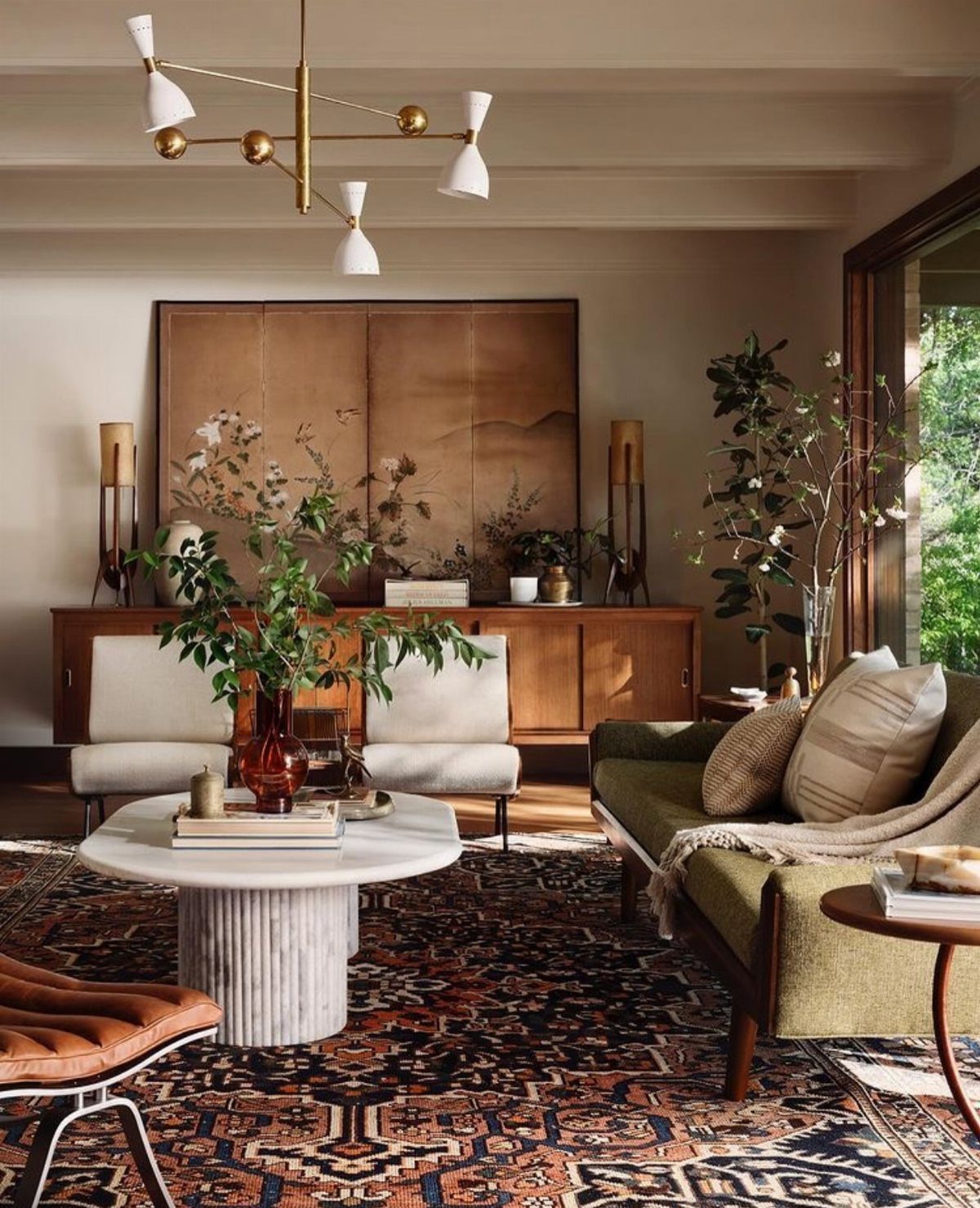 Living room with mid-century furniture, a marble table, and a patterned area rug.