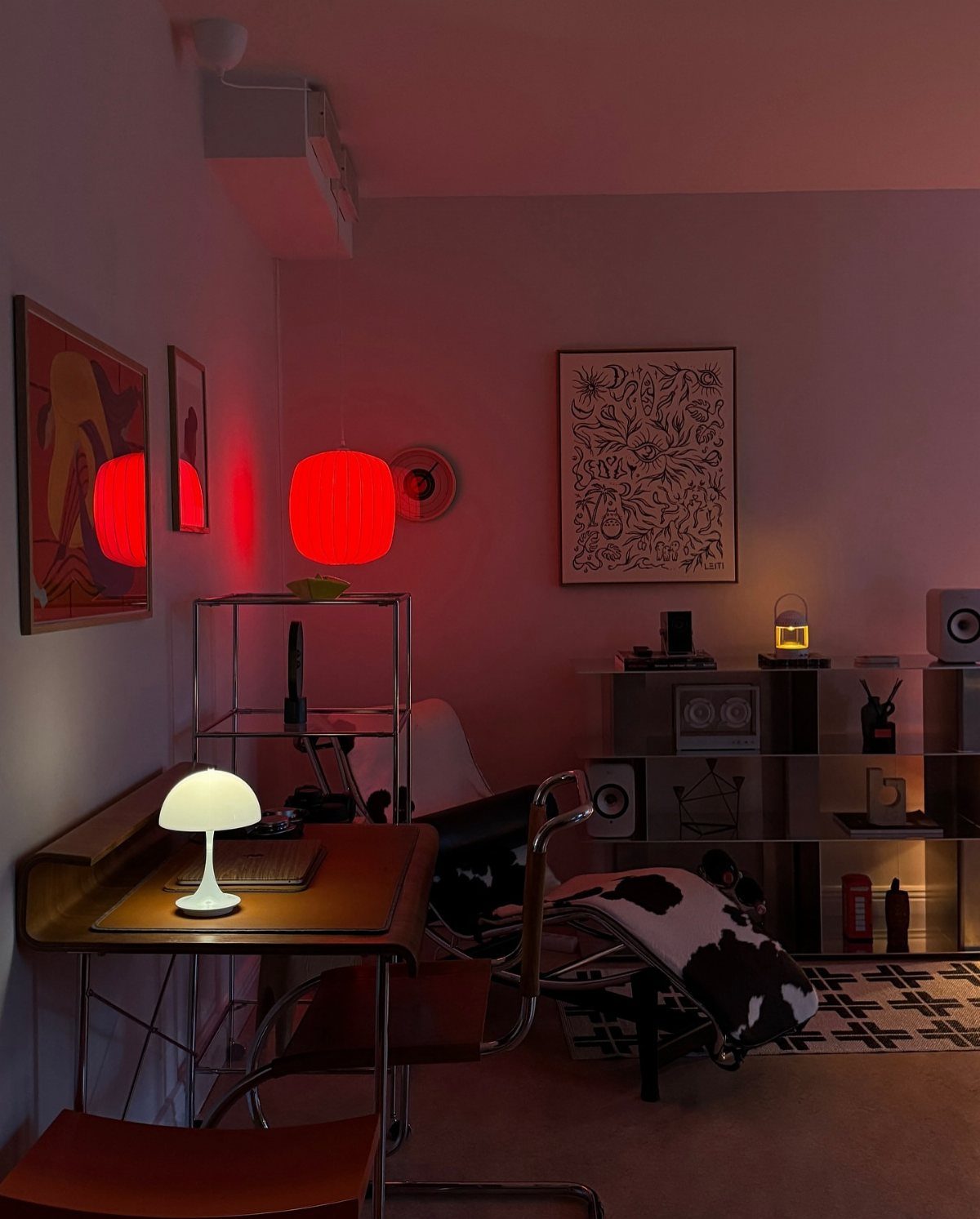 Mid-century modern room with a leather desk chair, mushroom lamp, and red pendant light.