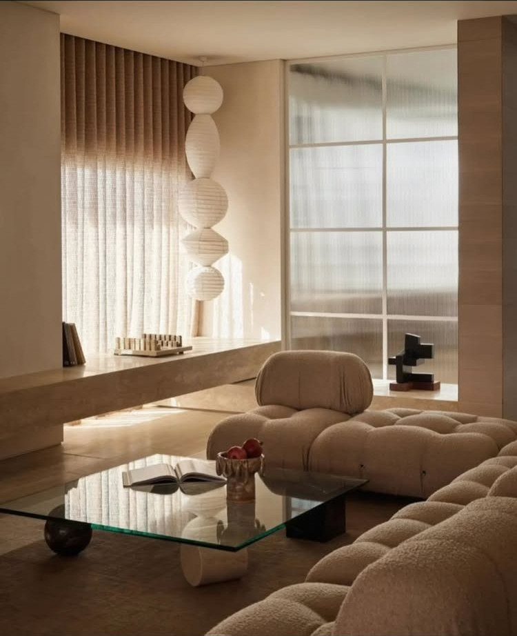 Curved modular sofa and sculptural sphere lamp in a neutral modern living room.