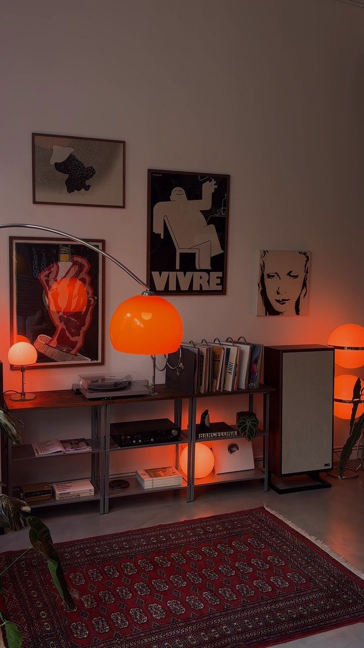 Mid-century modern room with orange globe lamps, vinyl records, and framed wall art.