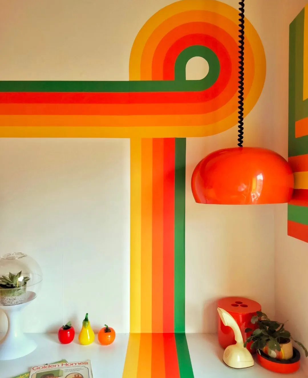 Curving yellow, orange, and green color bands on a white interior wall.