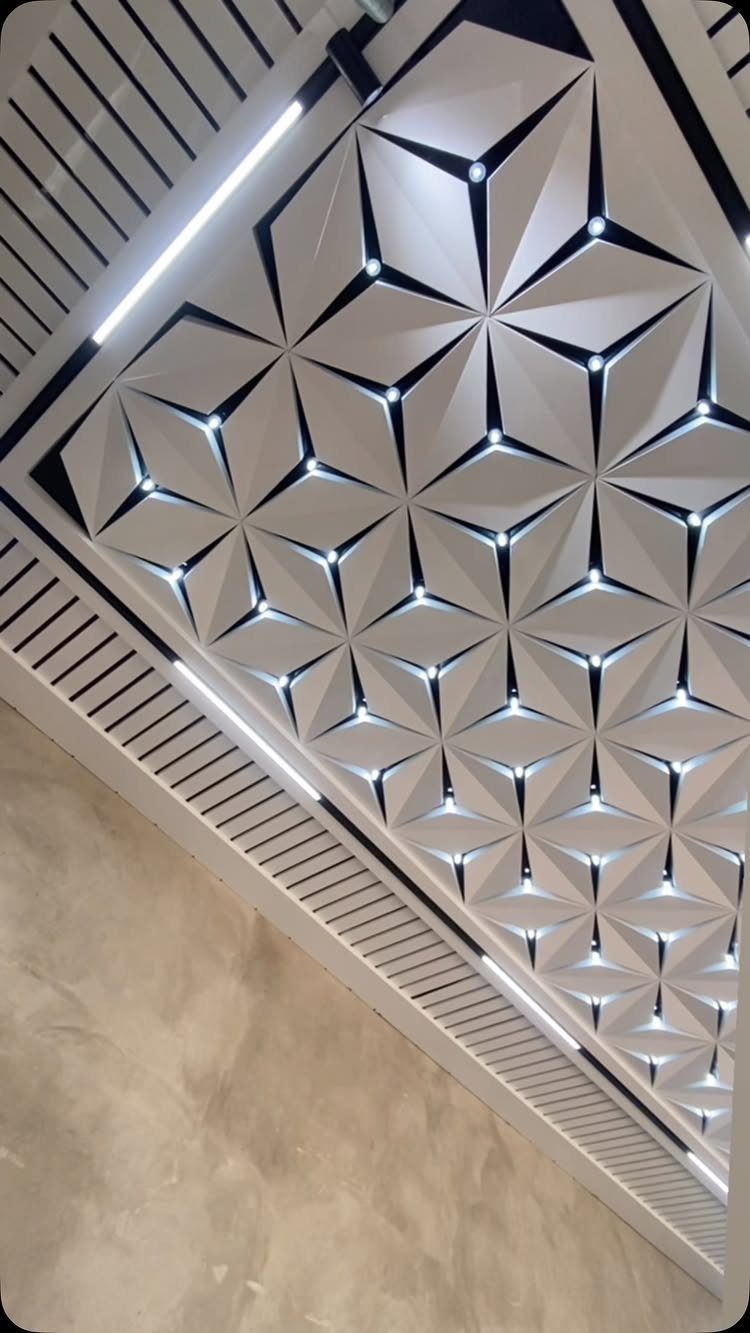 Geometric 3D white drop ceiling with integrated lights and linear slatted borders.
