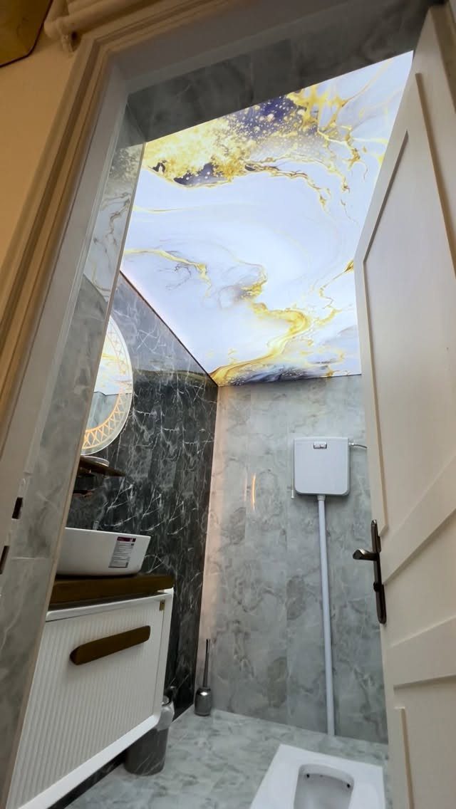 Marble patterned stretch drop ceiling in a modern grey marble bathroom